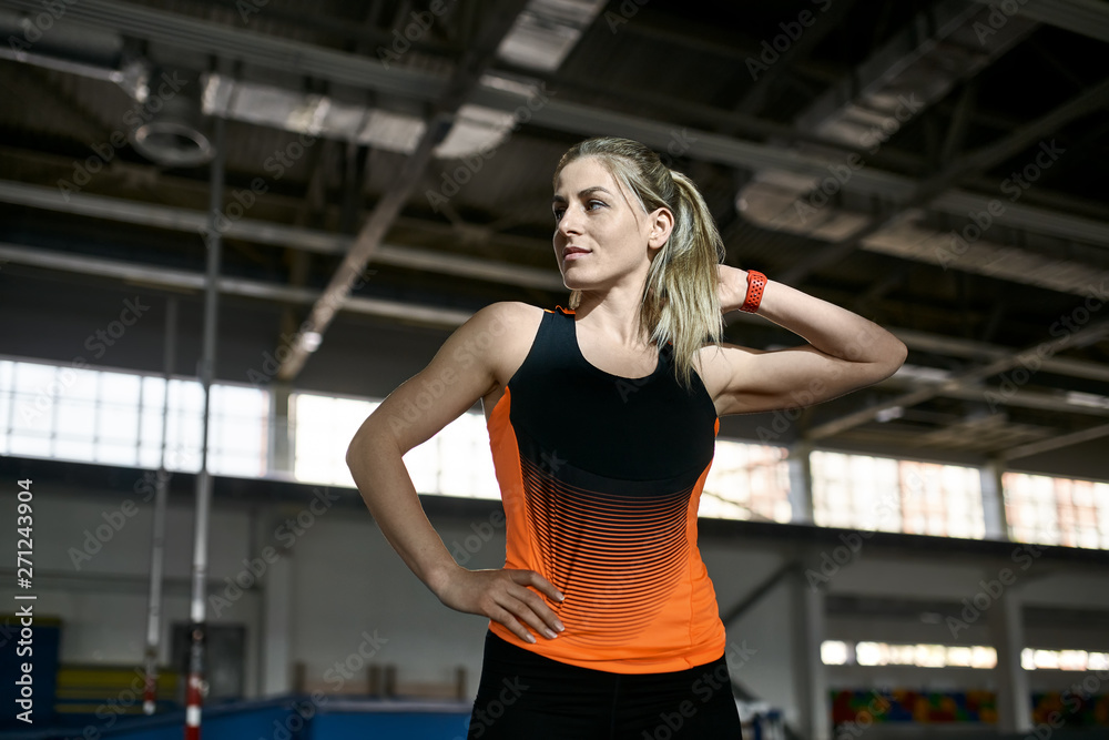 Sportive blonde woman posing at indoor stadium