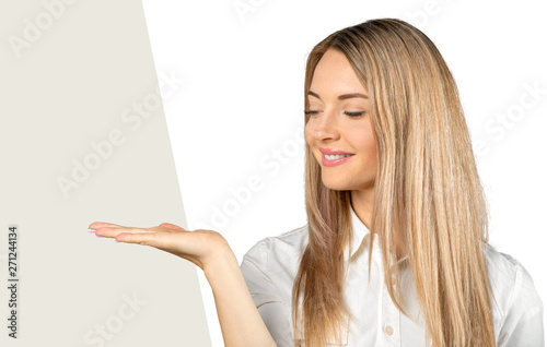 beautiful young businesswoman pointing at copy space isolated