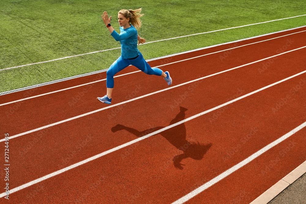 Fototapeta premium Sportive blonde woman training at open stadium
