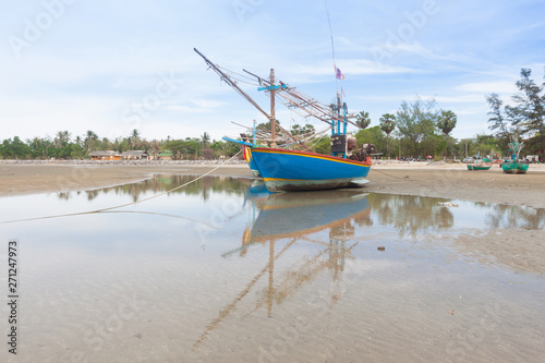Wooden fishing boat on the low tide beach