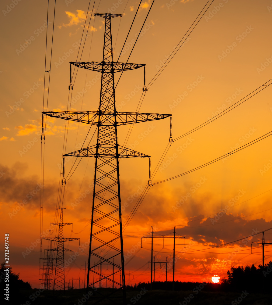 Silhouette High voltage electric towers at sunset time. High-voltage power lines. Electricity distribution station