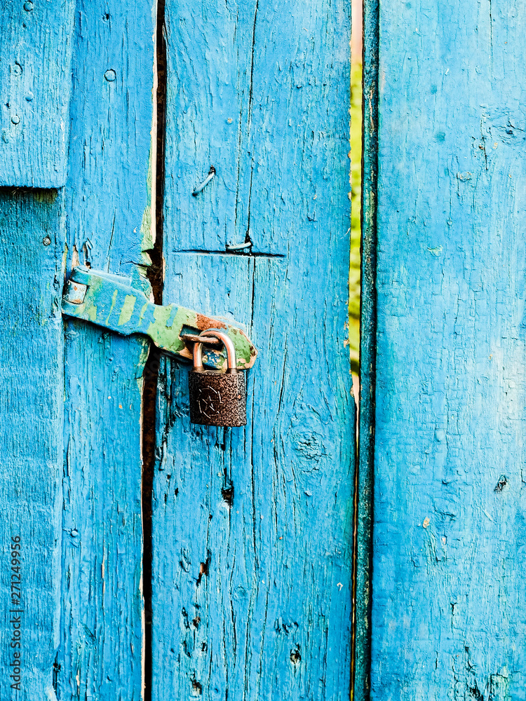 Blue wooden door with door handle and lock in village house Blue wooden door with door handle and lock in village house