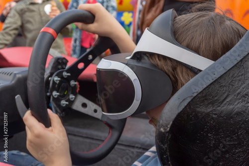 Child wearing VR glasses driving a car