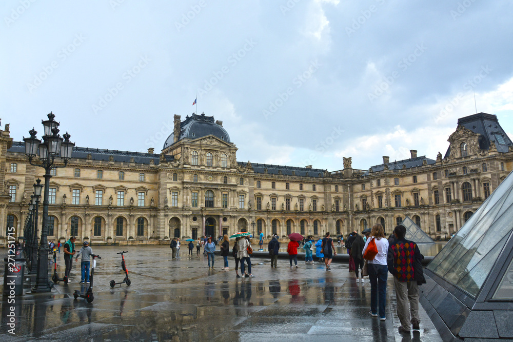 PARIS, FRANCE - MAY 25, 2019: Famous Paris Louvre. People in main courtyard (Cour Napoleon) 