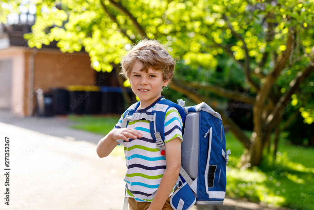 little kid boy with school satchel on first day to school