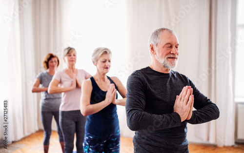 Group of senior people doing exercise in community center club.