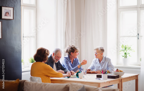 Group of senior people playing board games in community center club.