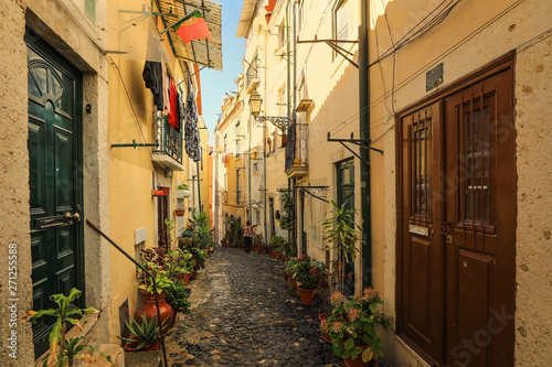 Fototapeta Naklejka Na Ścianę i Meble -  A narrow street in Alfama district in Lisbon, Portugal