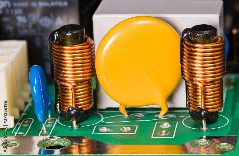 Varistor, inductors, capacitor and relay on green circuit board