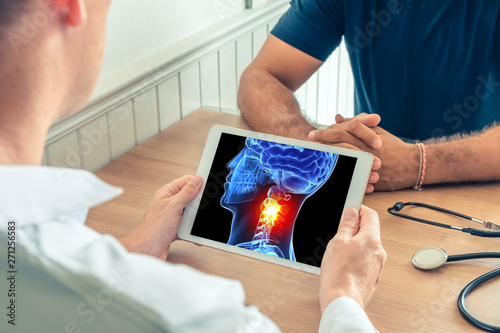 Doctor holding a digital tablet with x-ray of the 3D head of the patient with pain on the neck. Migraine headache concept