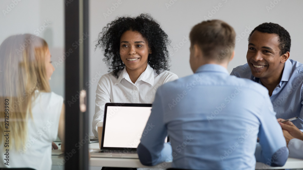 Multiracial businesspeople sitting in boardroom, discussing project, strategy Multiracial businesspeople sitting in boardroom, discussing project, strategy