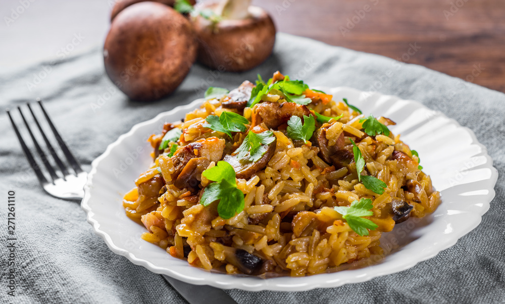 meat with Rice, mushroom and vegetables in white plate on wooden table background meat with Rice, mushroom and vegetables in white plate on wooden table background