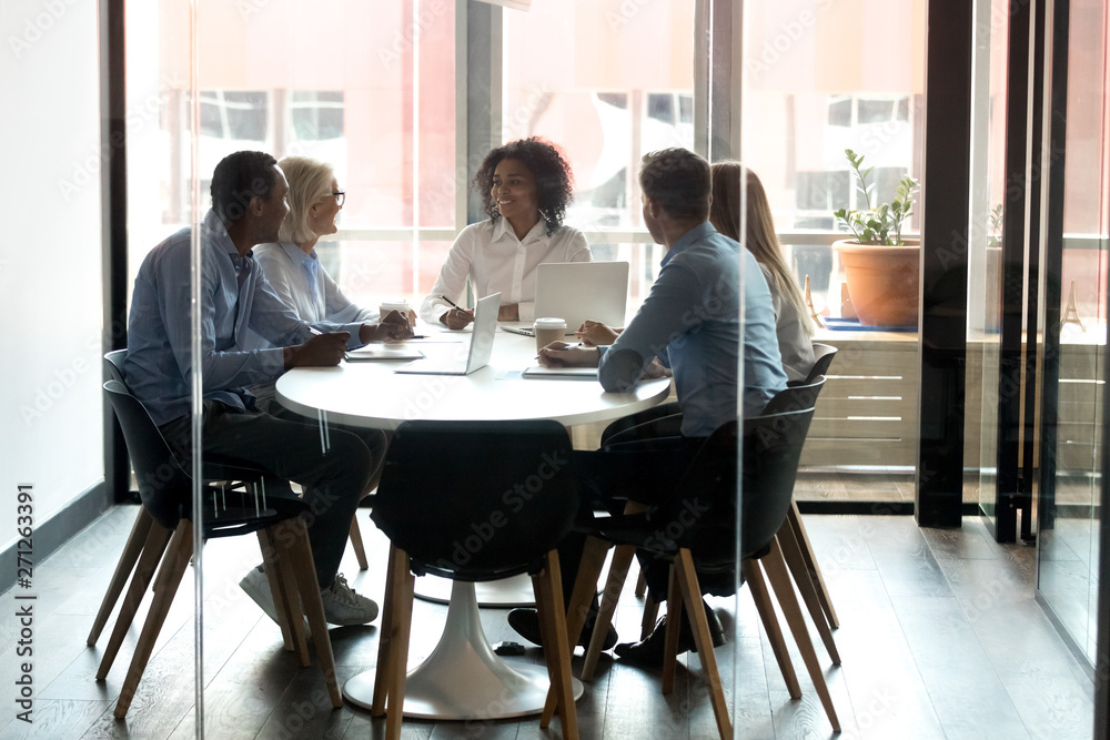 African American boss holding briefing with employees in boardroom