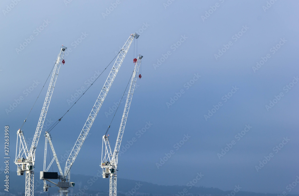 White tower cranes with blue sky