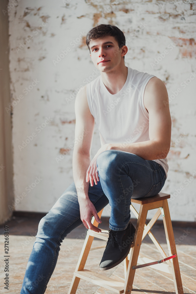 portrait of a young man in jeans and a sleeveless jacket portrait of a young man in jeans and a sleeveless jacket