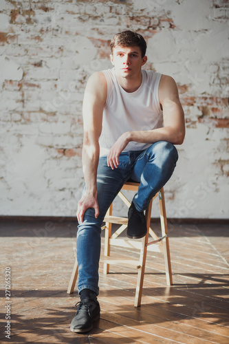 portrait of a young man in jeans and a sleeveless jacket