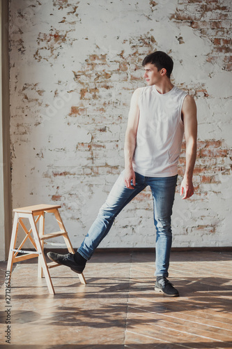 portrait of a young man in jeans and a sleeveless jacket