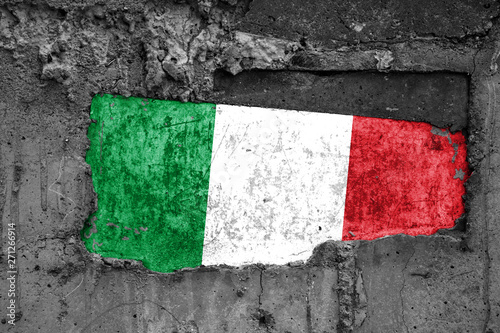 The flag of Italy on a dirty wooden surface, built into a concrete base, with scuffs and scratches. Loss or destruction conception.