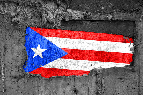 The flag of Puerto Rico on a dirty wooden surface, built into a concrete base, with scuffs and scratches. Loss or destruction conception.
