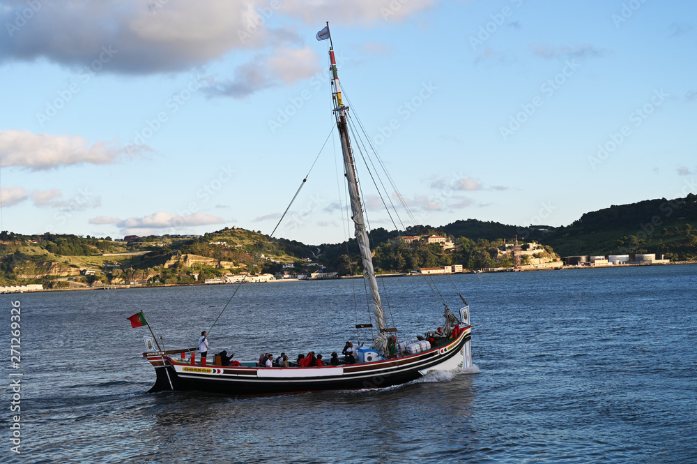 a traditional boat sailing along Tago river in Lisbon, Portugal