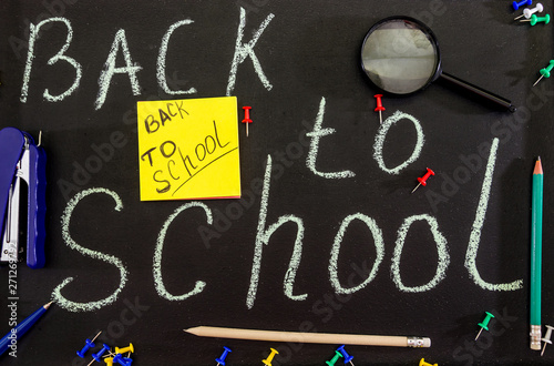 chalk inscription "back to school" on a black board. Stationery.