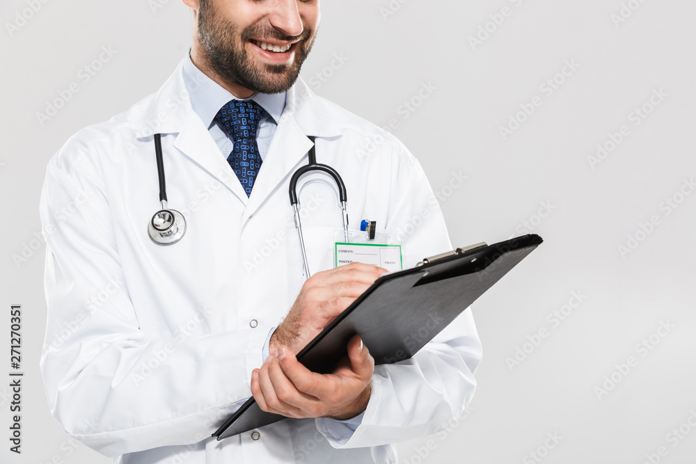 Portrait of handsome young medical doctor smiling and holding health card Portrait of handsome young medical doctor smiling and holding health card