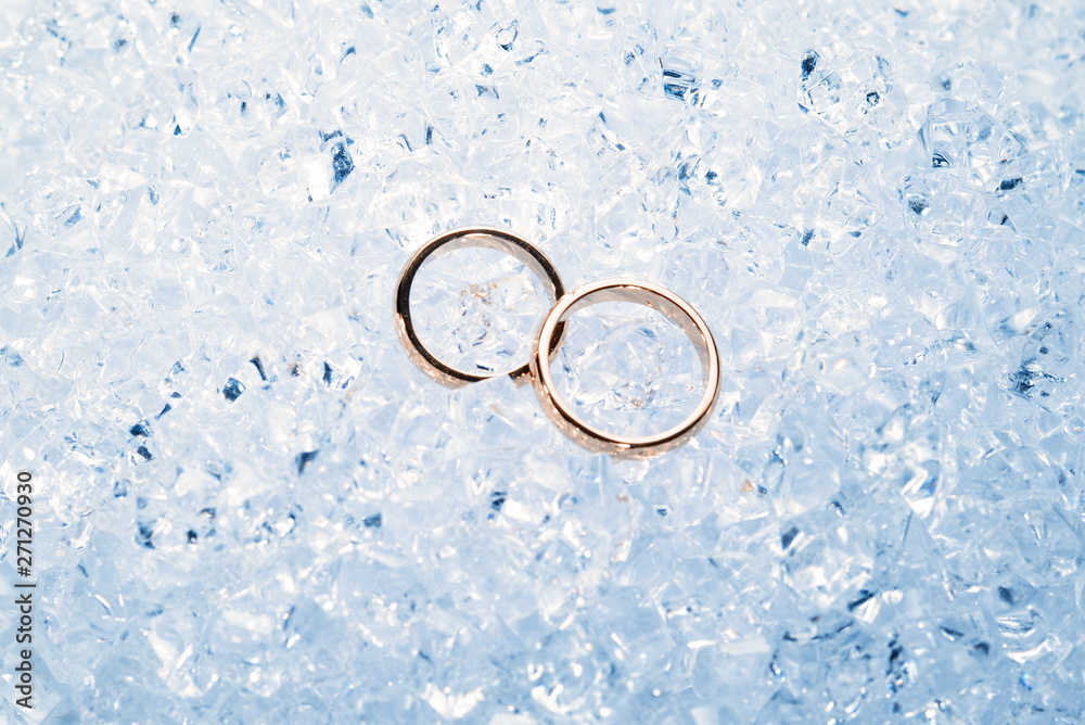 Two golden wedding rings on ice. Two golden wedding rings on ice.