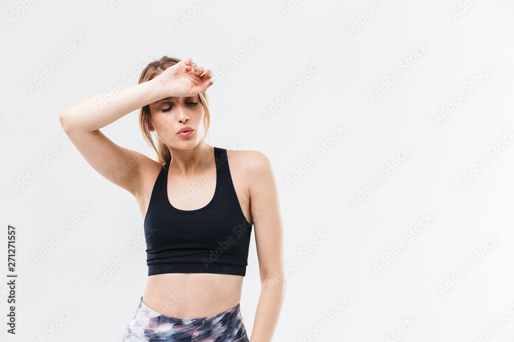 Image of tired blond woman 20s dressed in sportswear working out and doing exercises during fitness in gym Image of tired blond woman 20s dressed in sportswear working out and doing exercises during fitness in gym