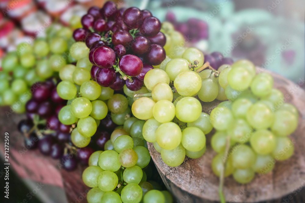 Concept of party or decoration with fruits. Beautiful assorted grapes on rustic wooden trunk, natural grapes direct from producer. Concept of party or decoration with fruits. Beautiful assorted grapes on rustic wooden trunk, natural grapes direct from producer.