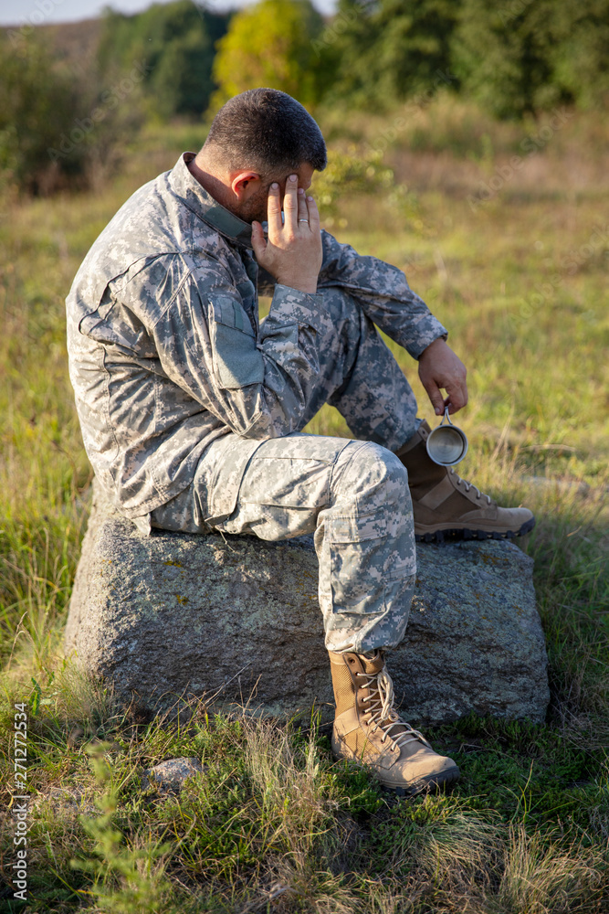 The soldier sits and rests. Sad and Tired soldier. Soldier