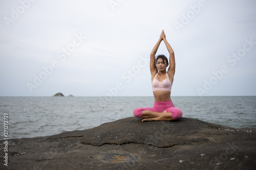 Asian girl practice Yoga on the beach Sunrise morning day