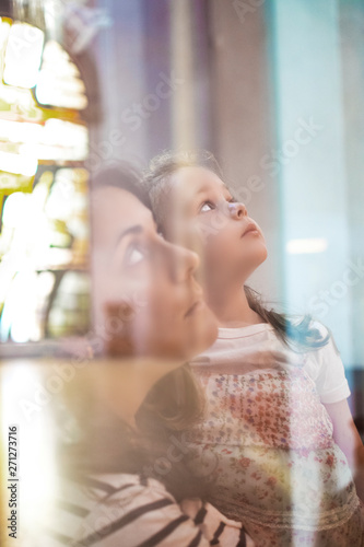 Mother and daughter in a church prying in a catechism education session. Christianity and catholicism concept and empty copy space for Editor's text. photo