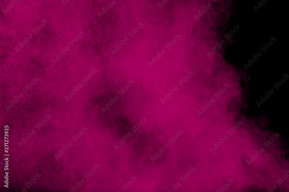 Pink powder explosion on black background.Pink dust particles splash.