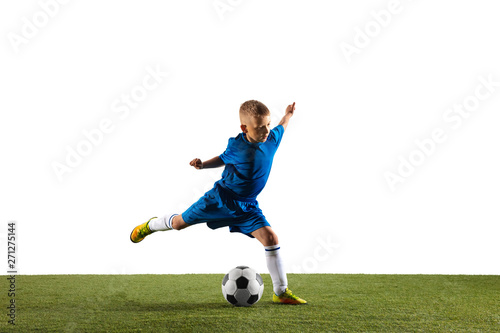 Young boy as a soccer or football player in sportwear making a feint or a kick with the ball for a goal on white studio background. Fit playing boy in action, movement, motion at game. © master1305