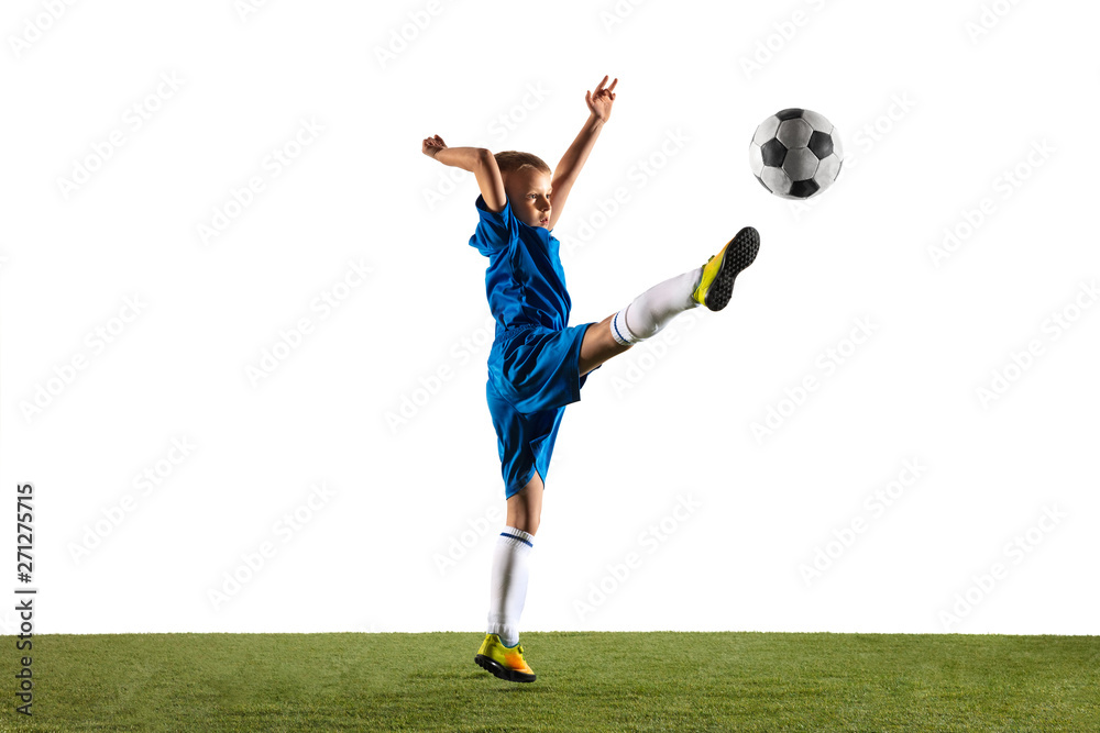 Young boy as a soccer or football player in sportwear making a feint or a kick with the ball for a goal on white studio background. Fit playing boy in action, movement, motion at game. Young boy as a soccer or football player in sportwear making a feint or a kick with the ball for a goal on white studio background. Fit playing boy in action, movement, motion at game.