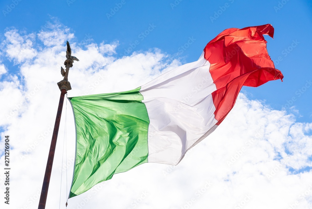 Flag of Italy in the wind. Sunny summer sky background
