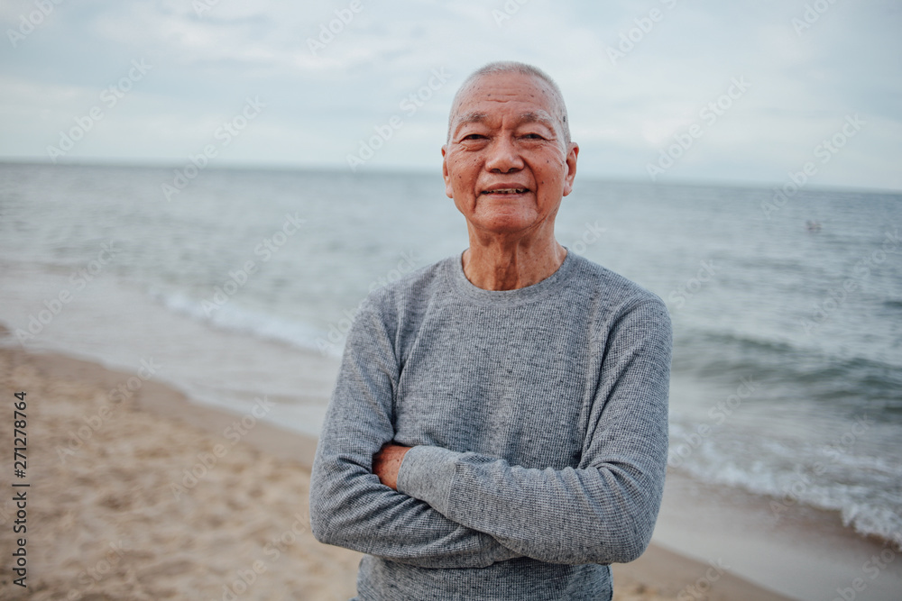 Fototapeta premium Asian Senior old man practice Tai chi and Yoga pose on the beach sunrise