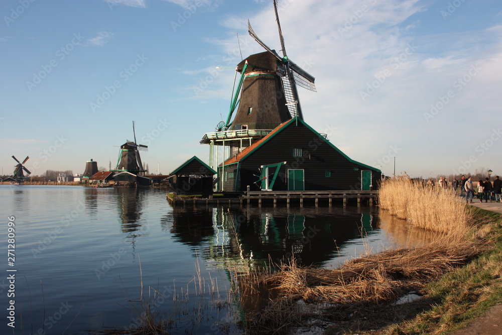 old dutch wooden windmill in zaanse schans on the water of the river Zaan