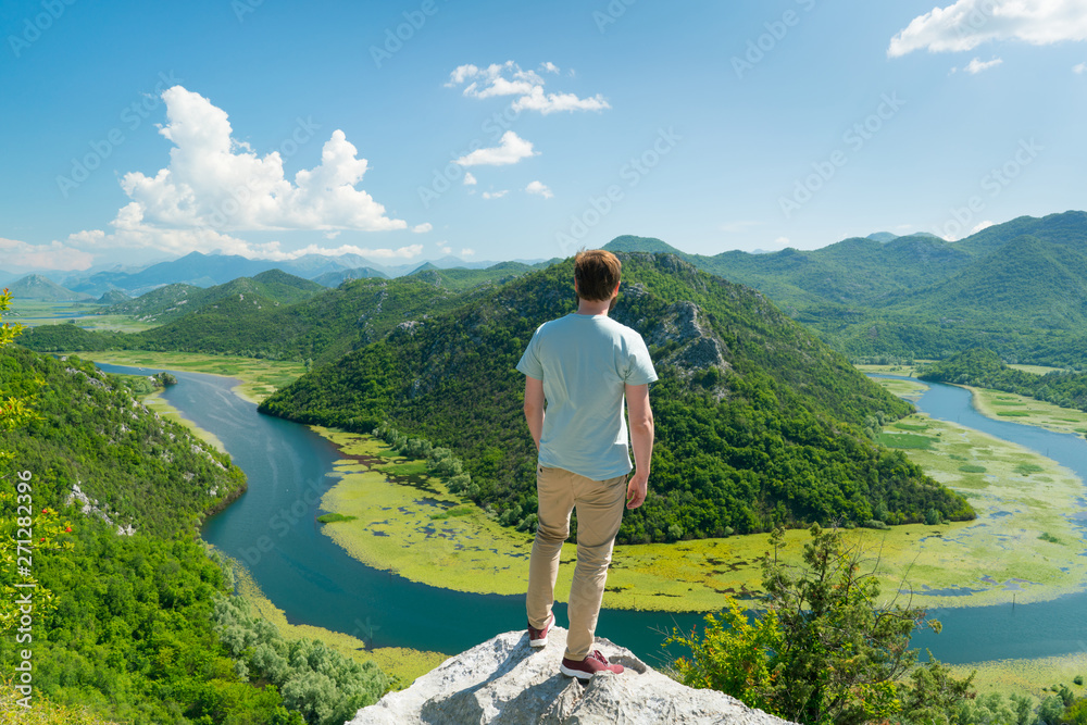 guy posing on the background of a curved river and mountains guy posing on the background of a curved river and mountains