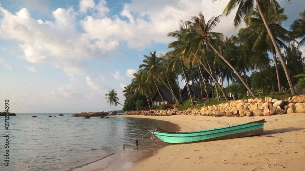 Green wooden boat stands on picturesque sandy beach in evening at sunset. Calm waves of Andaman Sea wash sand of the beach with tropical vegetation and palm trees on Phangan island. 50fps full hd. Green wooden boat stands on picturesque sandy beach in evening at sunset. Calm waves of Andaman Sea wash sand of the beach with tropical vegetation and palm trees on Phangan island. 50fps full hd.