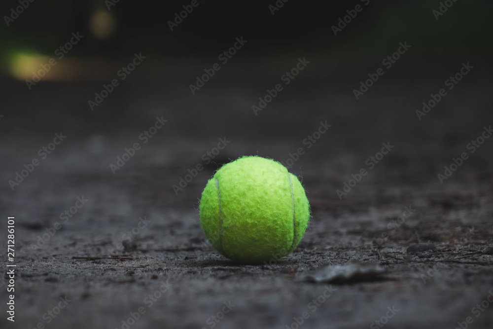 green tennis ball lying on the ground