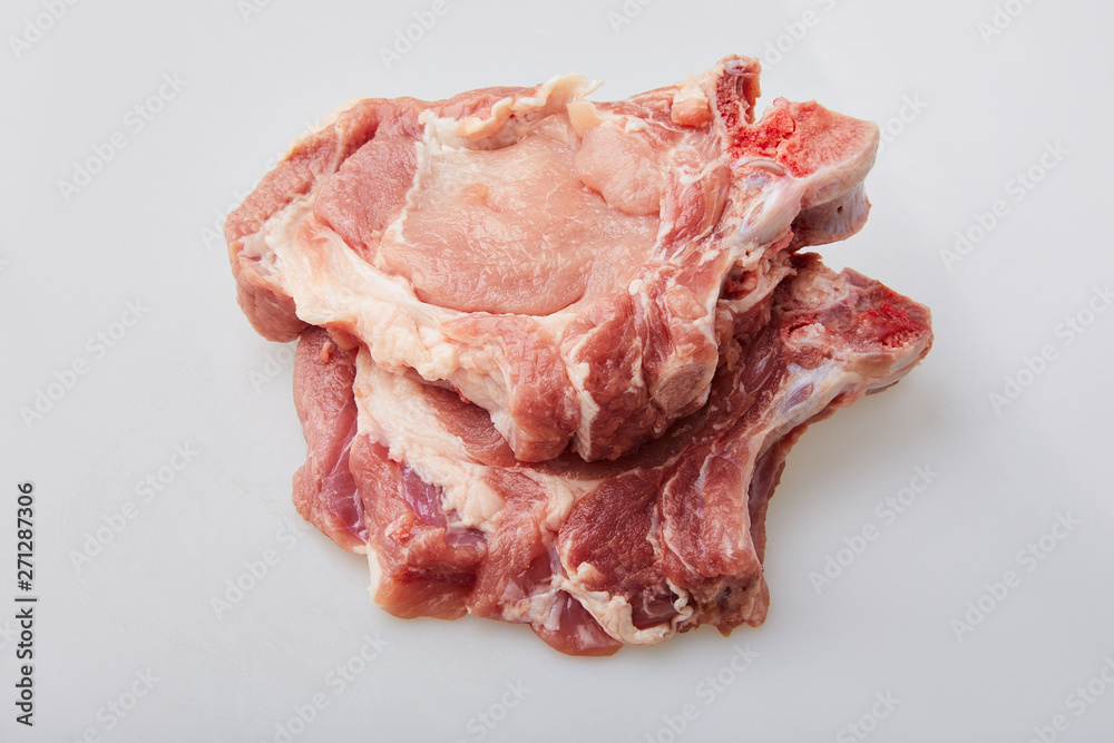 Raw pork loin isolated on white background. Raw fresh pork fillet steak with the bone. Sliced raw pork meat isolated. Raw pork loin isolated on white background. Raw fresh pork fillet steak with the bone. Sliced raw pork meat isolated.