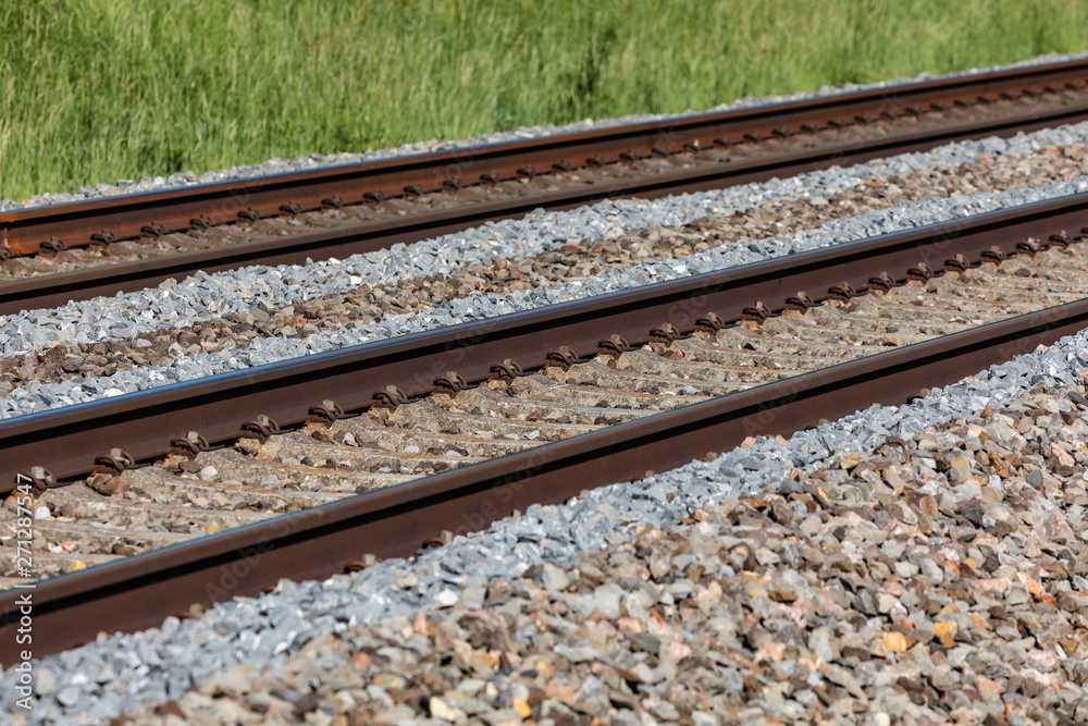 Eisenbahnschinen neben einer grünen Wiese Eisenbahnschinen neben einer grünen Wiese