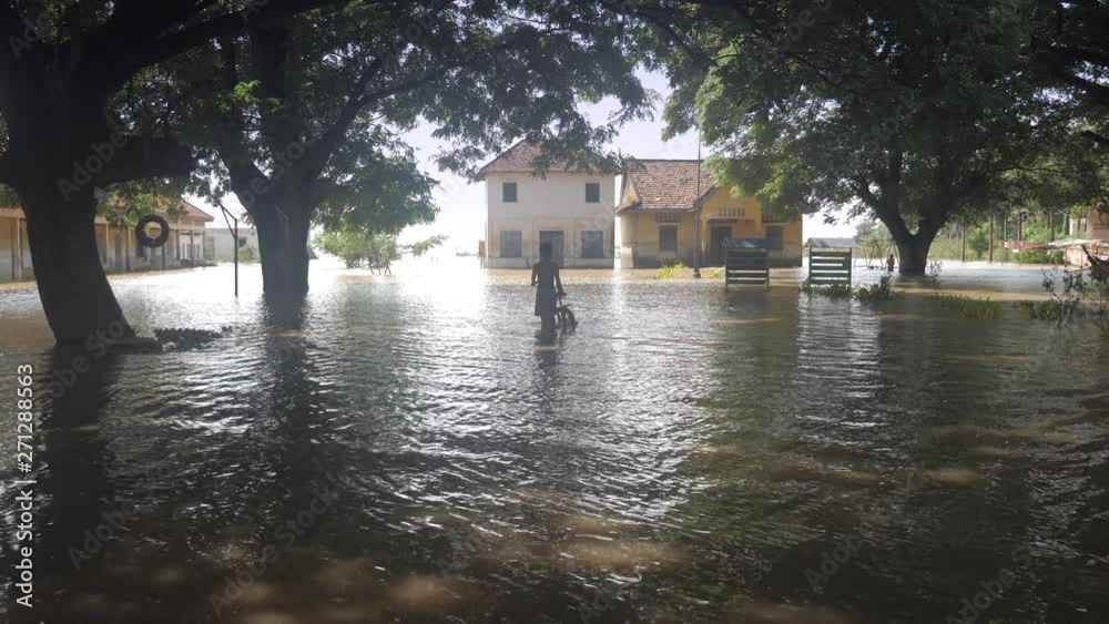 young boy pushing his bike inside a flooded school young boy pushing his bike inside a flooded school