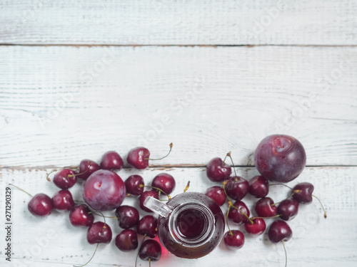 Delicious summer  lemonade with ice,cherry, e on wooden background.  Glass with cold, fresh drink or coctail on white table