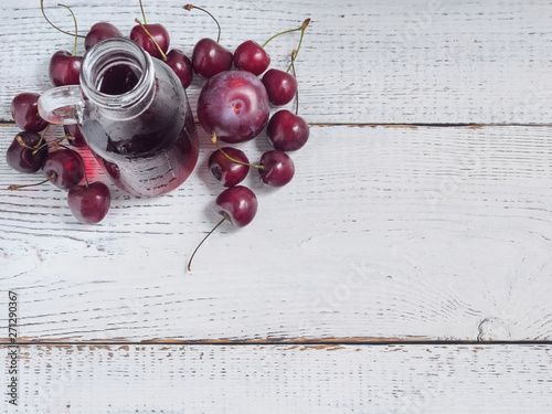 Delicious summer  lemonade with ice,cherry, e on wooden background.  Glass with cold, fresh drink or coctail on white table