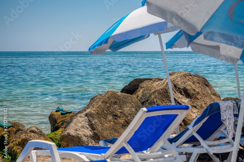 Obraz na płótnie Sun loungers and umbrellas on beach near stones, Odessa, Ukraine w salonie