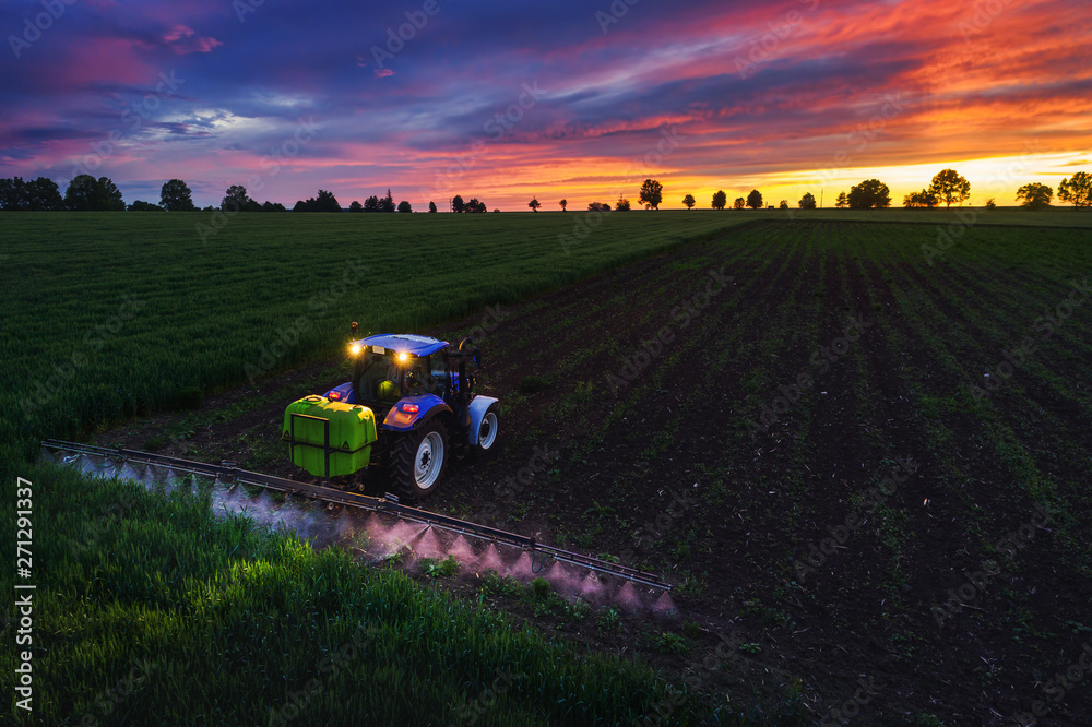 Tractor spraying field at spring Tractor spraying field at spring