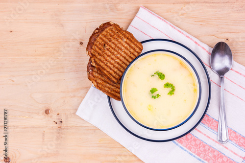 Cheese soup in a white plate with toasted bread