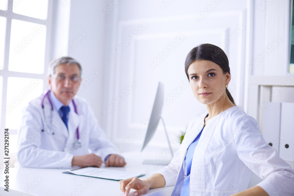 Two doctors smiling in consulting room in hospital Two doctors smiling in consulting room in hospital